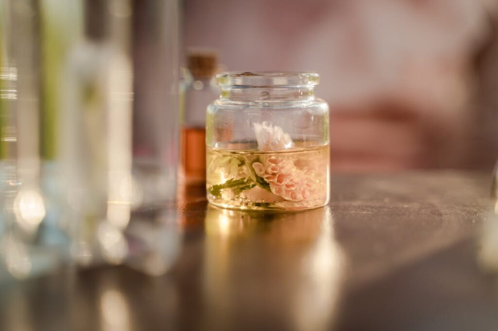 pexels photo 10536619 Close-up of a delicate flower submerged in a glass jar filled with liquid, on a table.