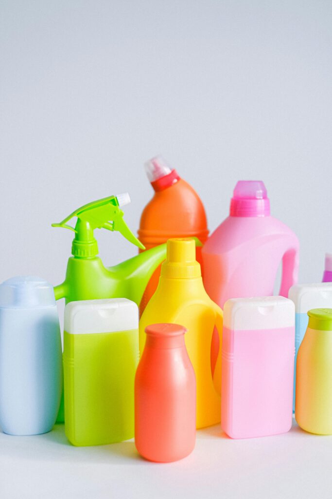 pexels photo 5217900 5217900 Composition of different colorful plastic containers with detergents for disinfect and daily routine placed on table against white background in room