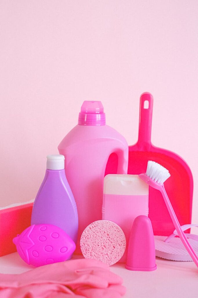 pexels photo 5218014 Set of assorted plastic containers with gloves brush and scoop for cleaning routine on pink background