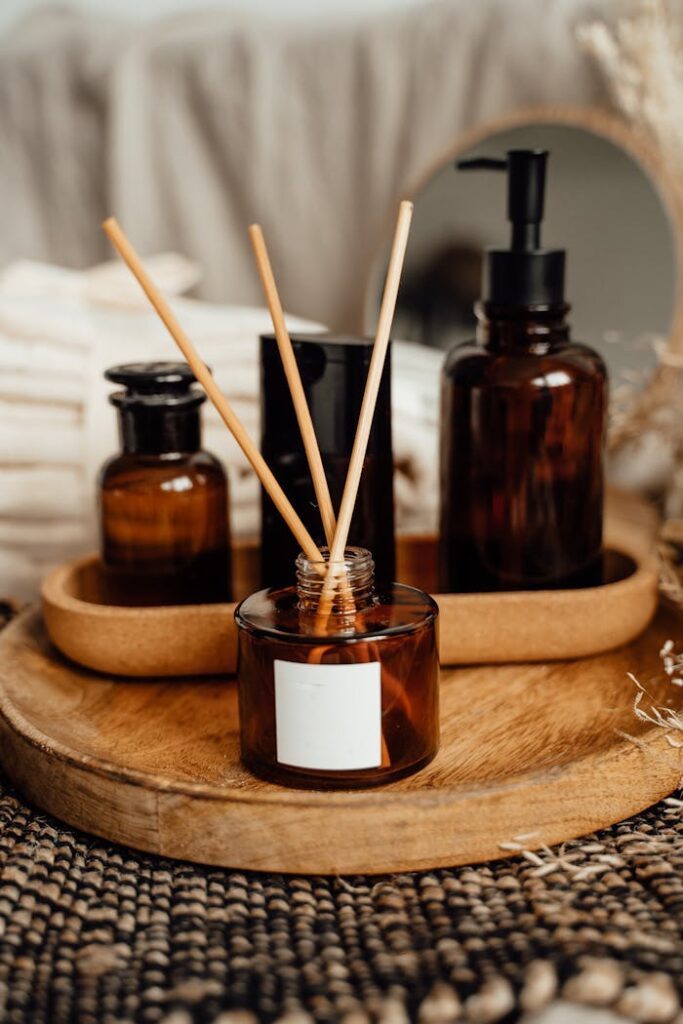 Elegant arrangement of aromatic reed diffuser and bottle on wooden tray, perfect for relaxation and decor.